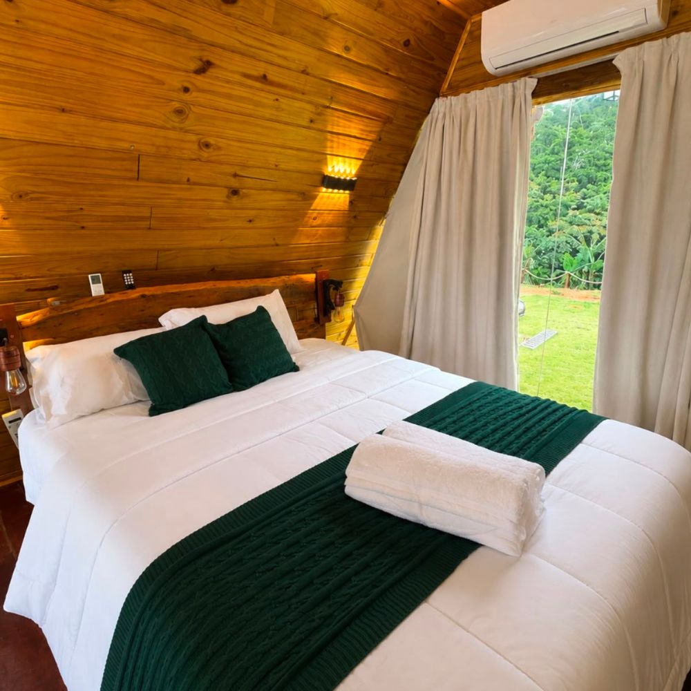 Quarto do Chalés La Montagna com cama preparada para casal